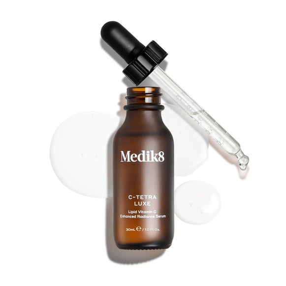 Medik8 C-Tetra Luxe flaska med dropper, omgiven av serumdroppar-5