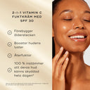 Leende kvinna med strålande hud rör vid sitt ansikte. Bredvid står text som beskriver Medik8 Daily Radiance Vitamin C som en 2-i-1 fuktkräm med SPF 30, med fördelar som återfuktning, lyster och skydd mot ålderstecken.