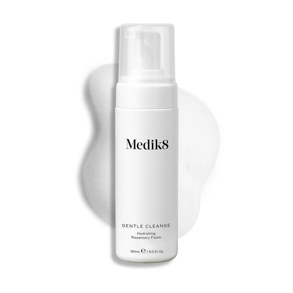 Produktbild av Medik8 Gentle Cleanse, en återfuktande rosmarinskumrengöring i en vit flaska med produktens kräm i bakgrunden.-13