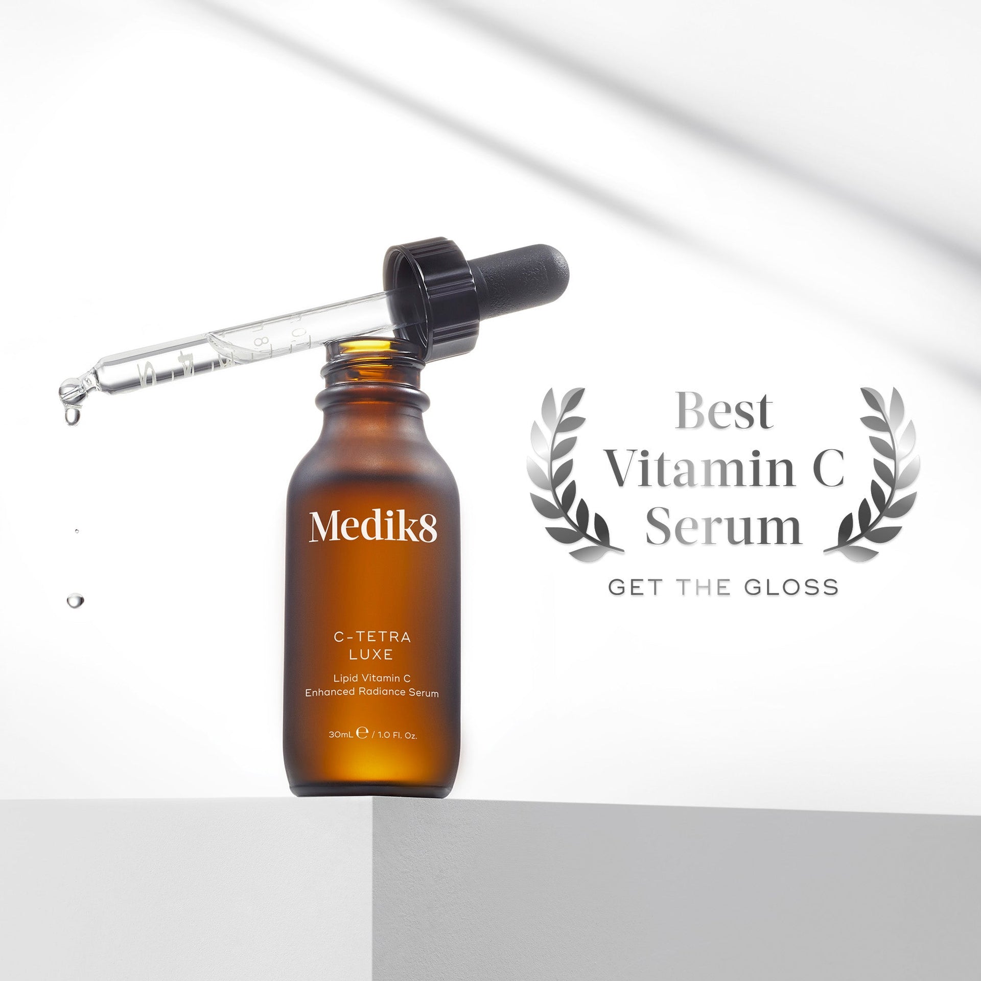 En brun glasflaska med Medik8 C-Tetra Luxe serum och pipett. Text intill förklarar att produkten har utsetts till bästa C-vitaminserum