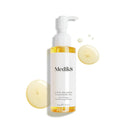 Produktbild av Medik8 Lipid-Balance Cleansing Oil, en rengöringsolja i en genomskinlig pumpflaska, tillsammans med ljusgula droppar i bakgrunden.
