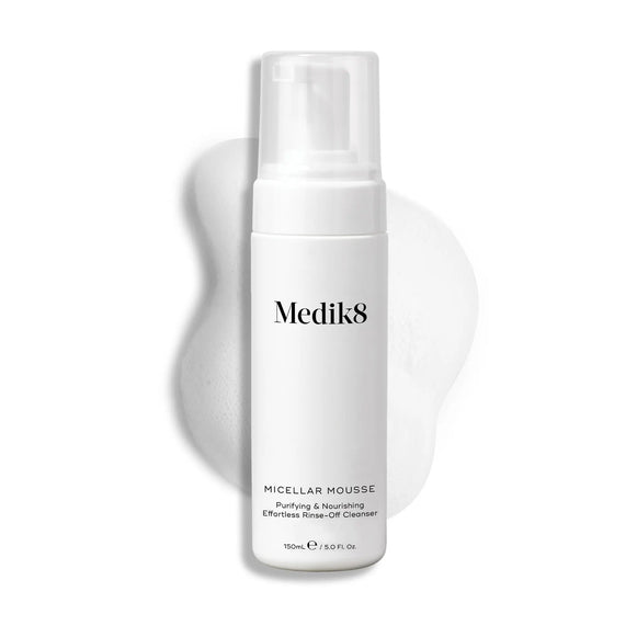 Produktbild av Medik8 Micellar Mousse, ett skumrengöringsmedel i en vit flaska med en pump, tillsammans med en bakgrund av mjukt skum.-26