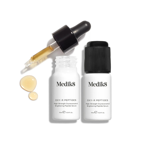 Produktbild av Medik8 Oxy-R Peptides, två vita flaskor med droppformad pipett och lite serum droppat bredvid flaskorna.-7