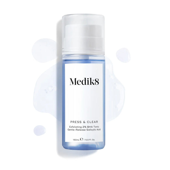 Produktbild av Medik8 Press & Clear, blå flaska med lite tonic utspridd i bakgrunden.-49