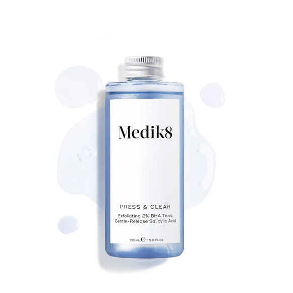Produktbild av Medik8 Press & Clear Refill, blå flaska med en stängd kapsyl och lite tonic utspridd i bakgrunden.-22