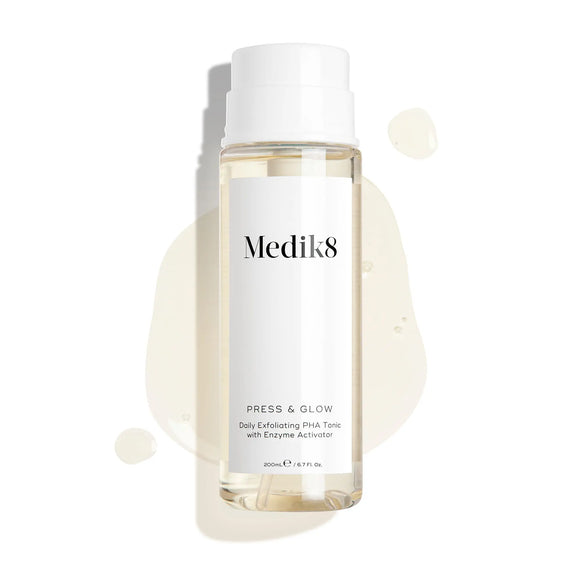 Produktbild av Medik8 Press & Glow, genomskinlig flaska med lite tonic utspridd i bakgrunden.-9