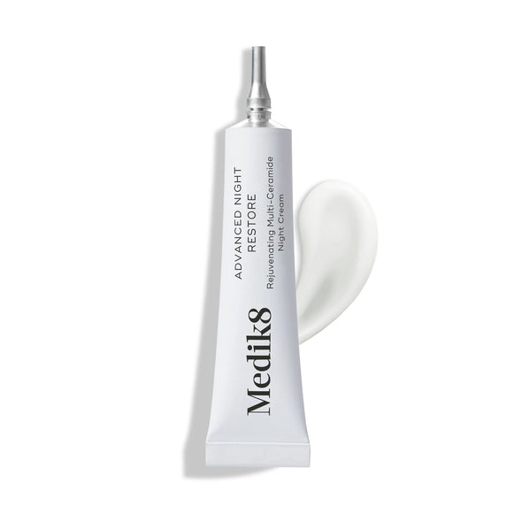 Tub med Medik8 Advanced Night Restore™ (Lyxprov) nattkräm i vit förpackning och krämens mjuka konsistens bredvid tuben på vit bakgrund.-63
