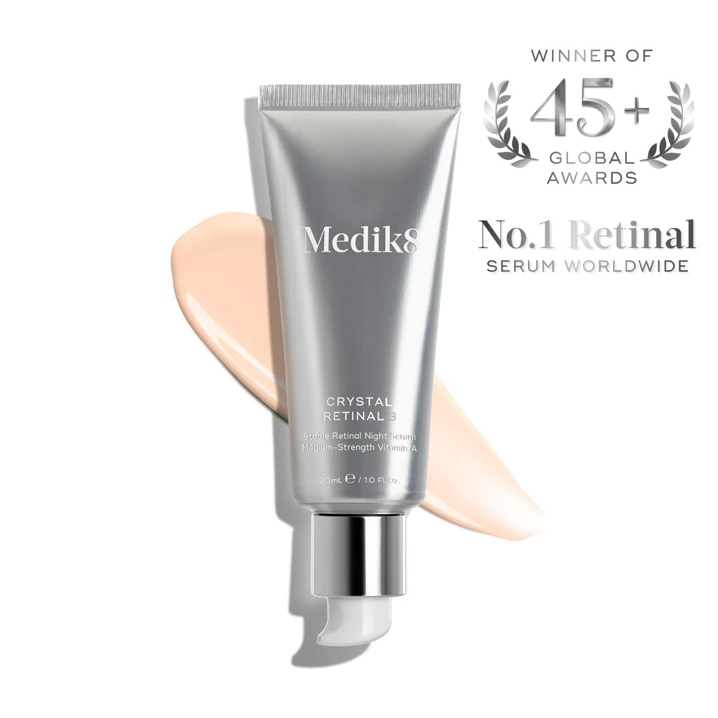 Produktbild av Crystal Retinal serum från Medik8 i en silverfärgad förpackning med en ljusbeige kräm i bakgrunden, utvald som världens bästa retinal serum.
