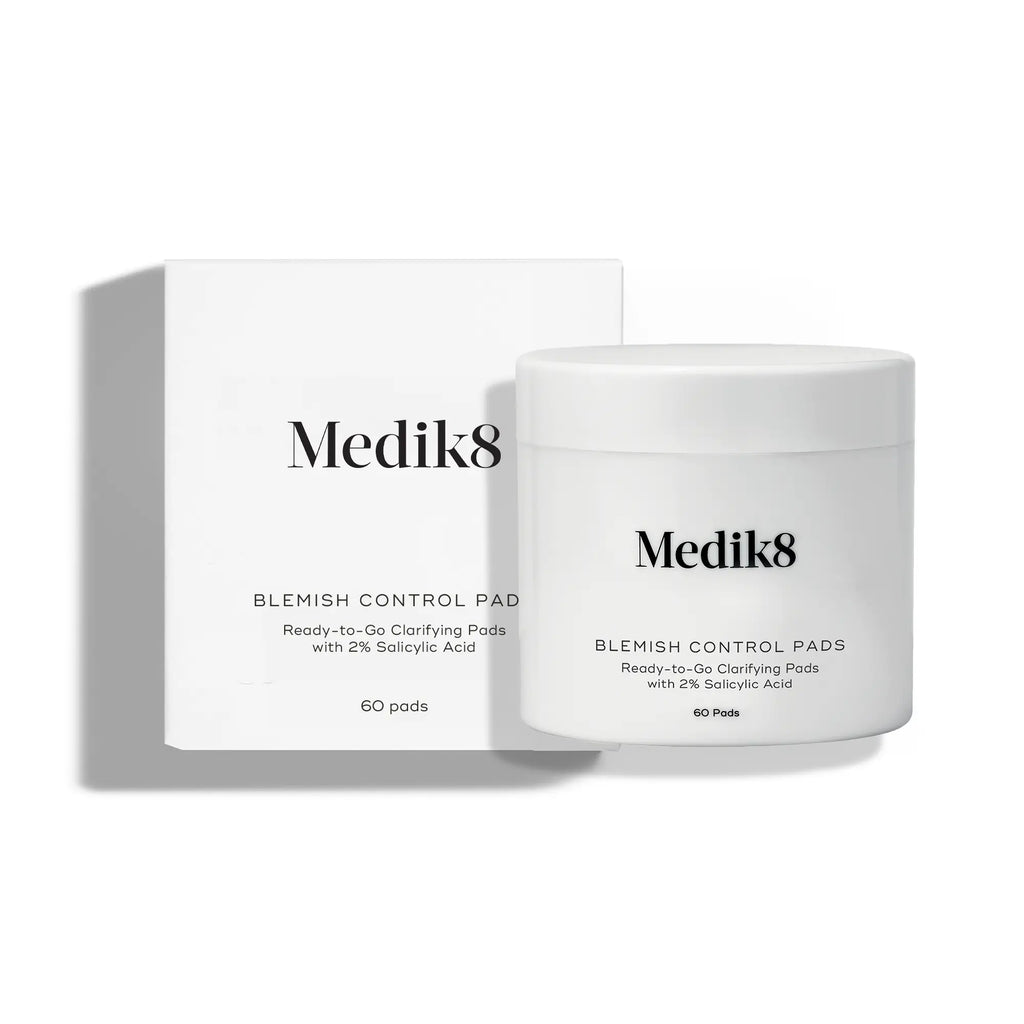 Medik8 Blemish Control Pads – en vit burk med ansiktsrengörande pads, bredvid en vit kartongförpackning med svart text. Innehåller 60 pads med 2 % salicylsyra.