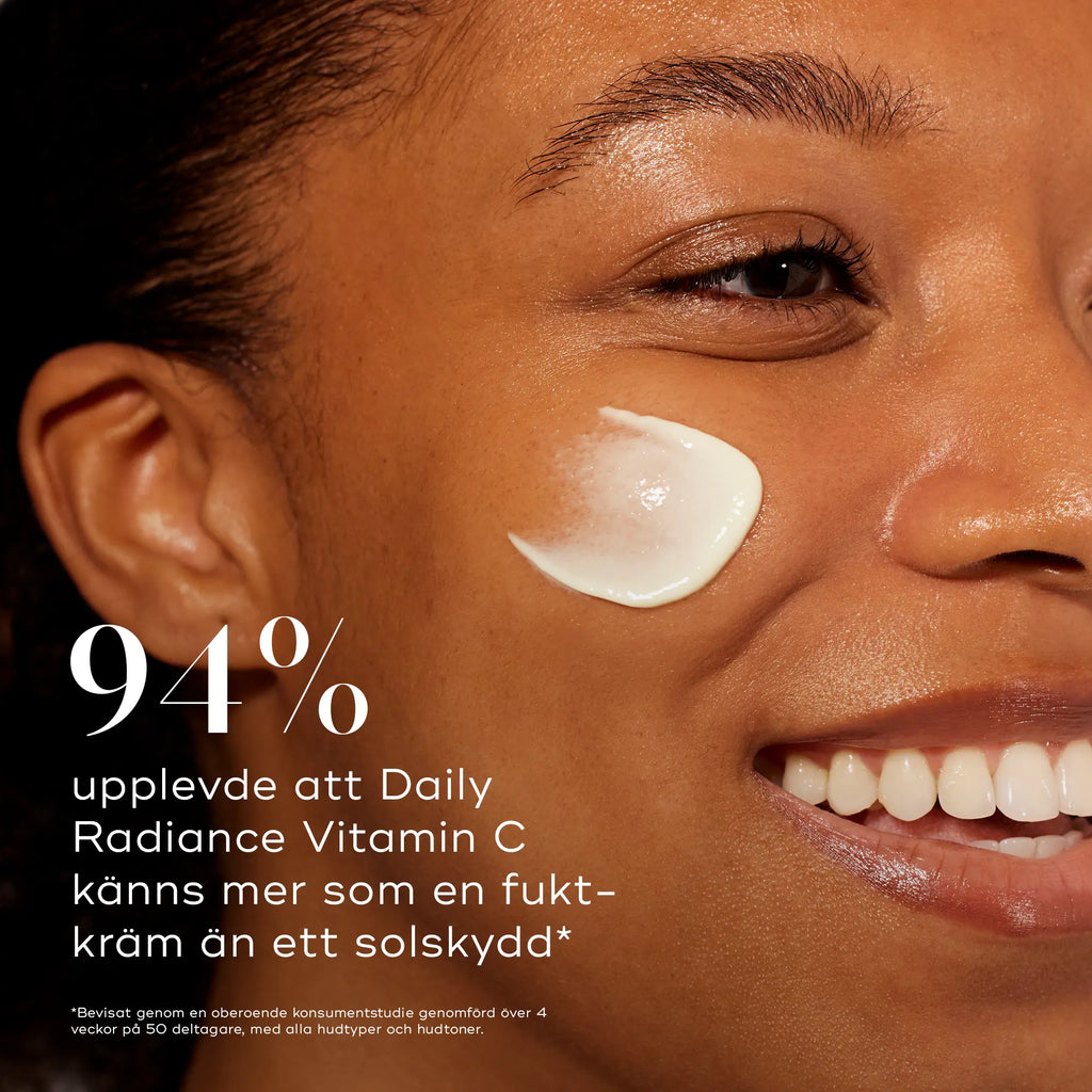 Leende kvinna med en klick av Medik8 Daily Radiance Vitamin C på kinden. Texten bredvid visar att 94 % av användarna upplevde att produkten känns mer som en fuktkräm än solskydd.