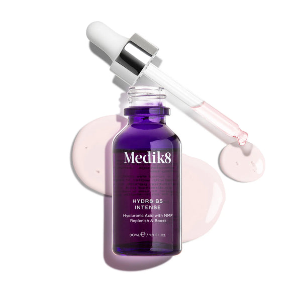 Produktbild av Medik8 Hydr8 B5 Intense, ett återfuktande serum i en lila glasflaska med pipett, tillsammans med droppar av serumet i bakgrunden.-17
