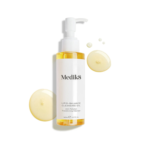 Produktbild av Medik8 Lipid-Balance Cleansing Oil, en rengöringsolja i en genomskinlig pumpflaska, tillsammans med ljusgula droppar i bakgrunden.-21