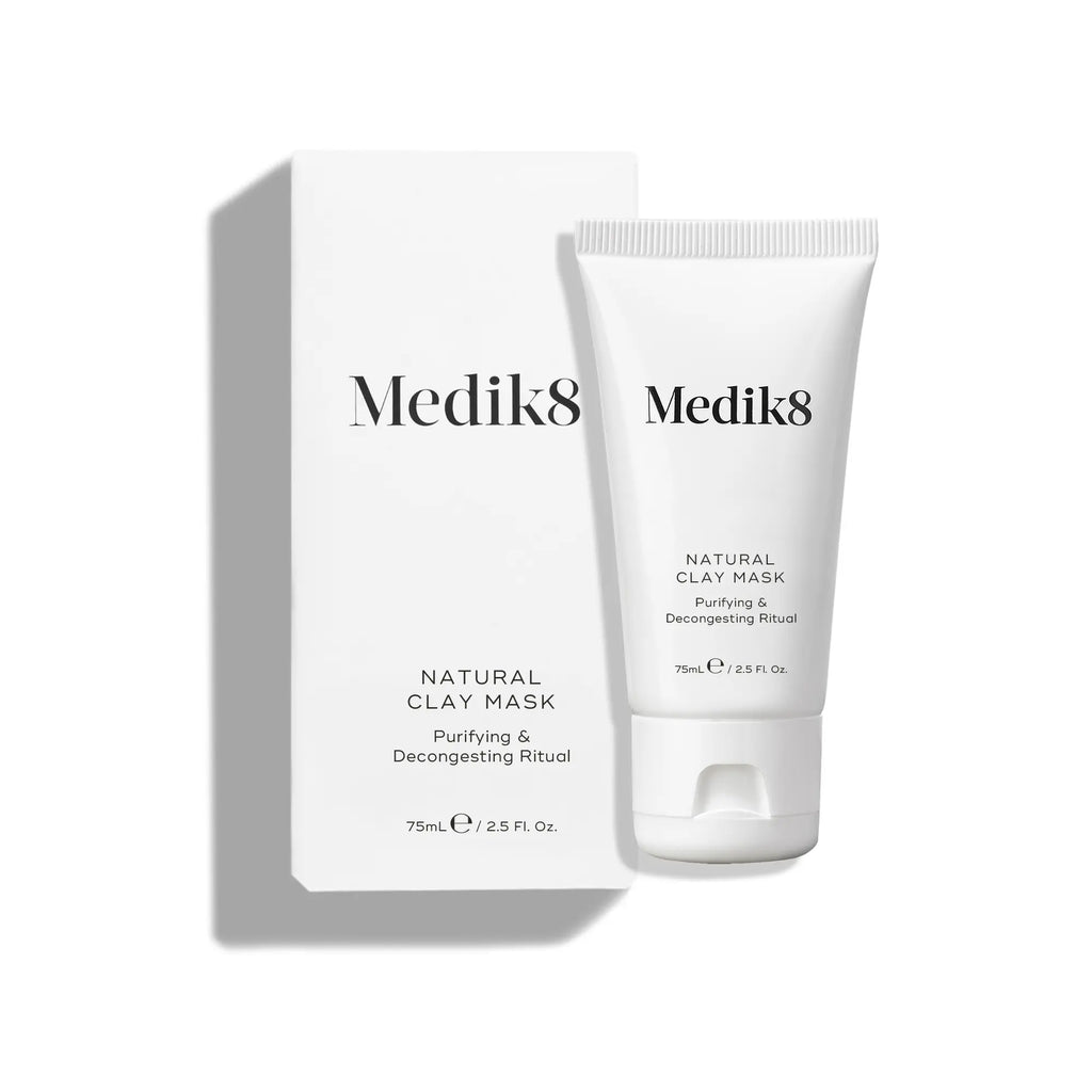 Produktbild av Medik8 Natural Clay Mask, en vit tub bredvid förpackningen på en grå yta.