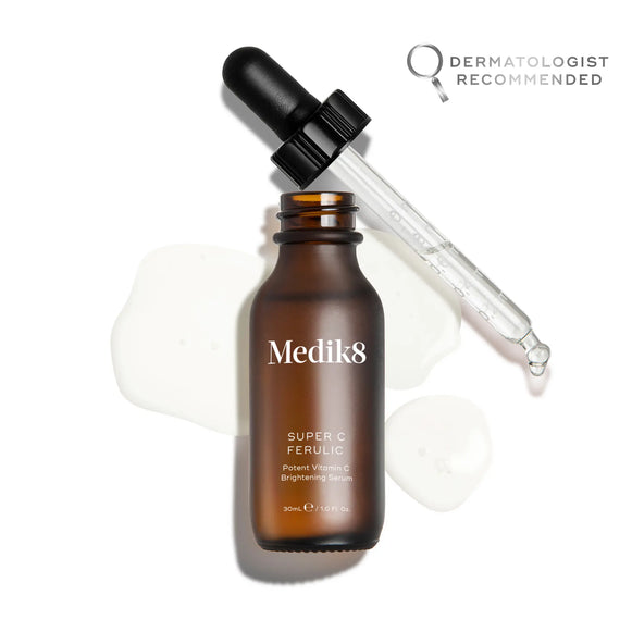 Produktbild av Medik8 Super C Ferulic, brun glasflaska med pipett och serum utspridd i bakgrunden.-7